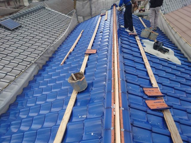 稲美町の葺き替え工事で棟瓦を施工中の職人